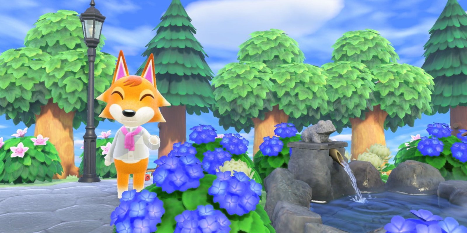 Chief waves while standing by a light post surrounded by flowers.