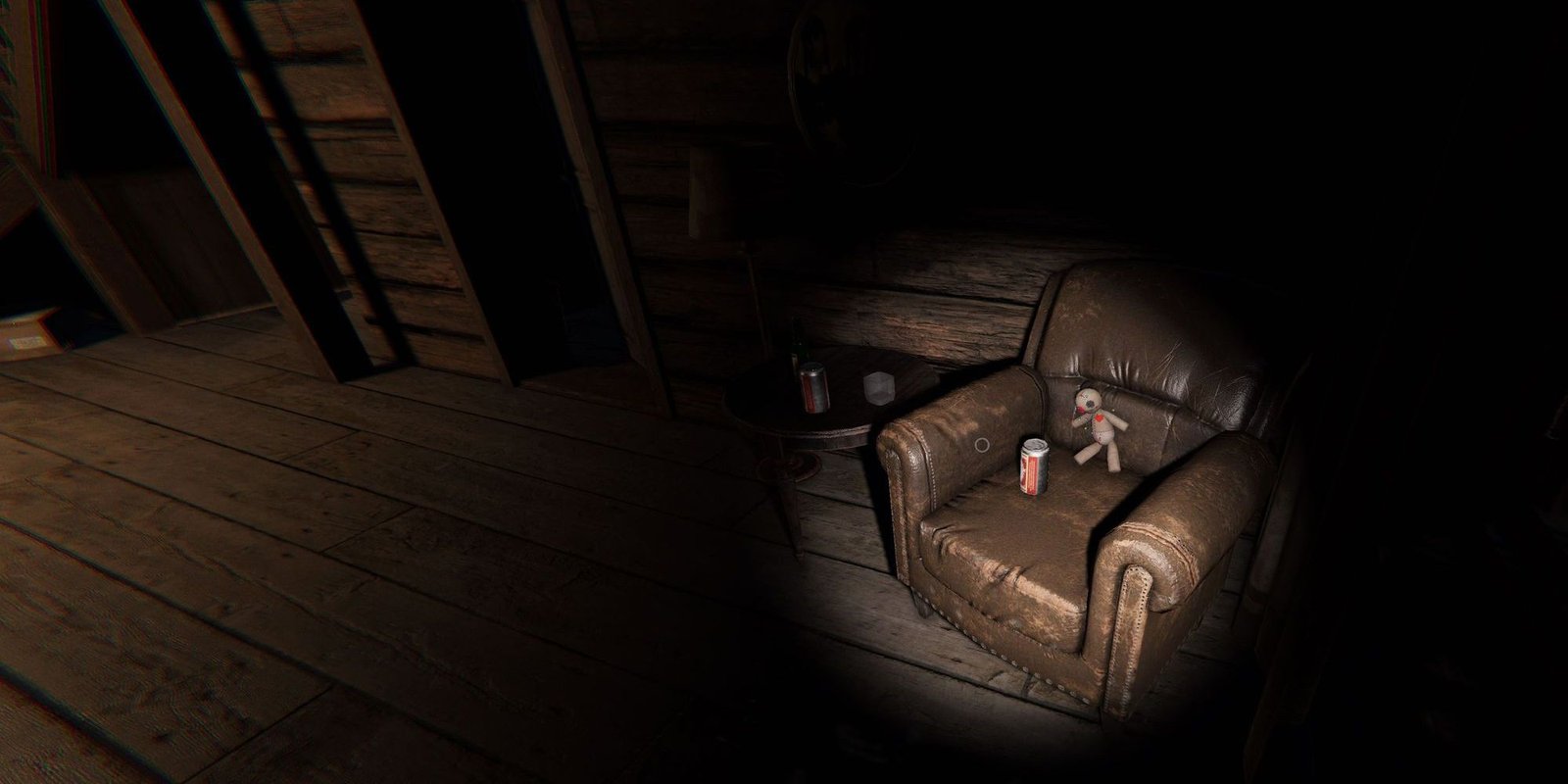 Image depicts a small voodoo doll sat on a large leather chair with a can in front of it. This image is from Bleasdale Farmhouse in Phasmophobia.
