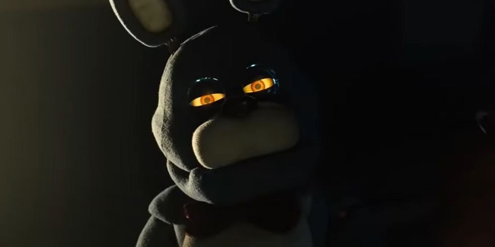 FNAF movie Bonnie in a dark room staring with glowing yellow eyes.