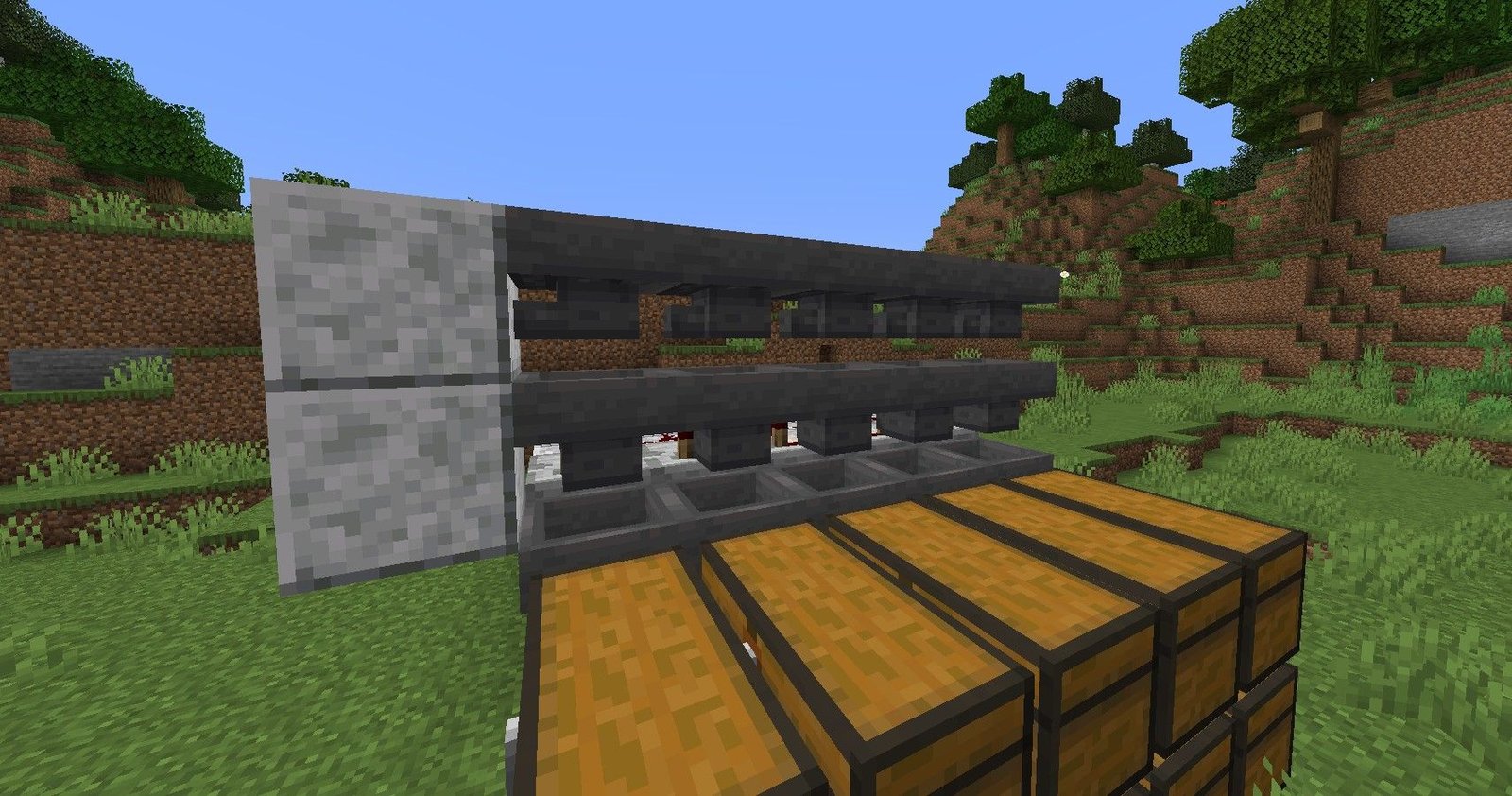 The process of building a Minecraft auto-sorter, with two rows of hoppers being placed. 