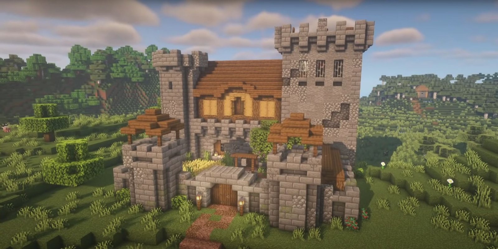 An image from Minecraft of a small Survival Castle, made out of stone and oak wood. This castle is designed with a small courtyard, two larger turrets, and a main structure towards the back of the base.