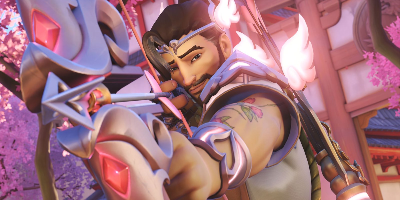 Hanzo dressed as cupid in Overwatch 2, aiming his bow at the camera with a smile.