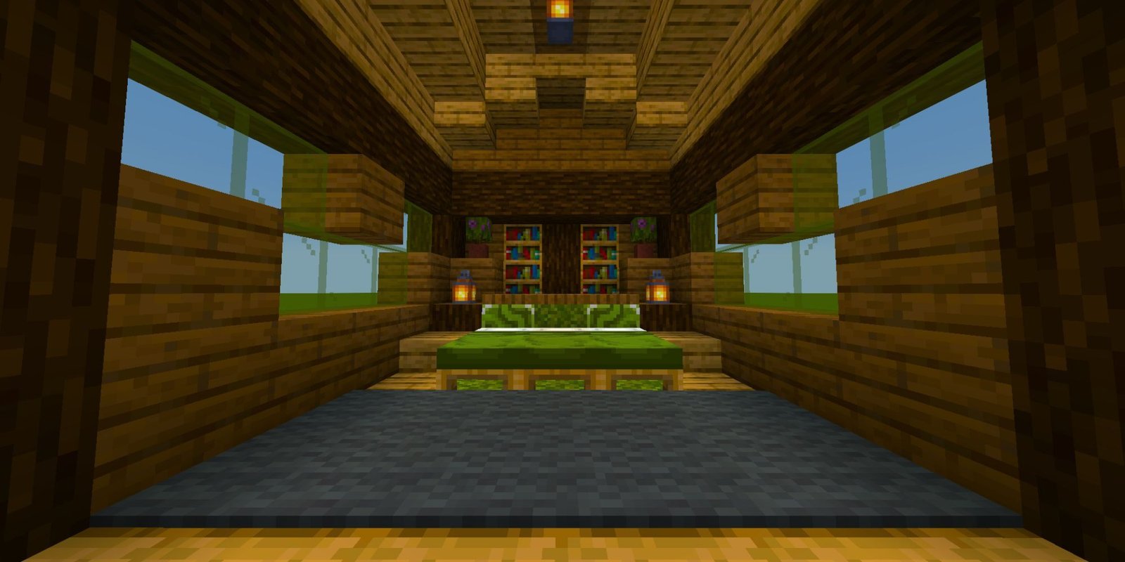 A cozy bedroom with a large, green bed, dark gray carpet, some bookshelves, green tinted windows, and lanterns.