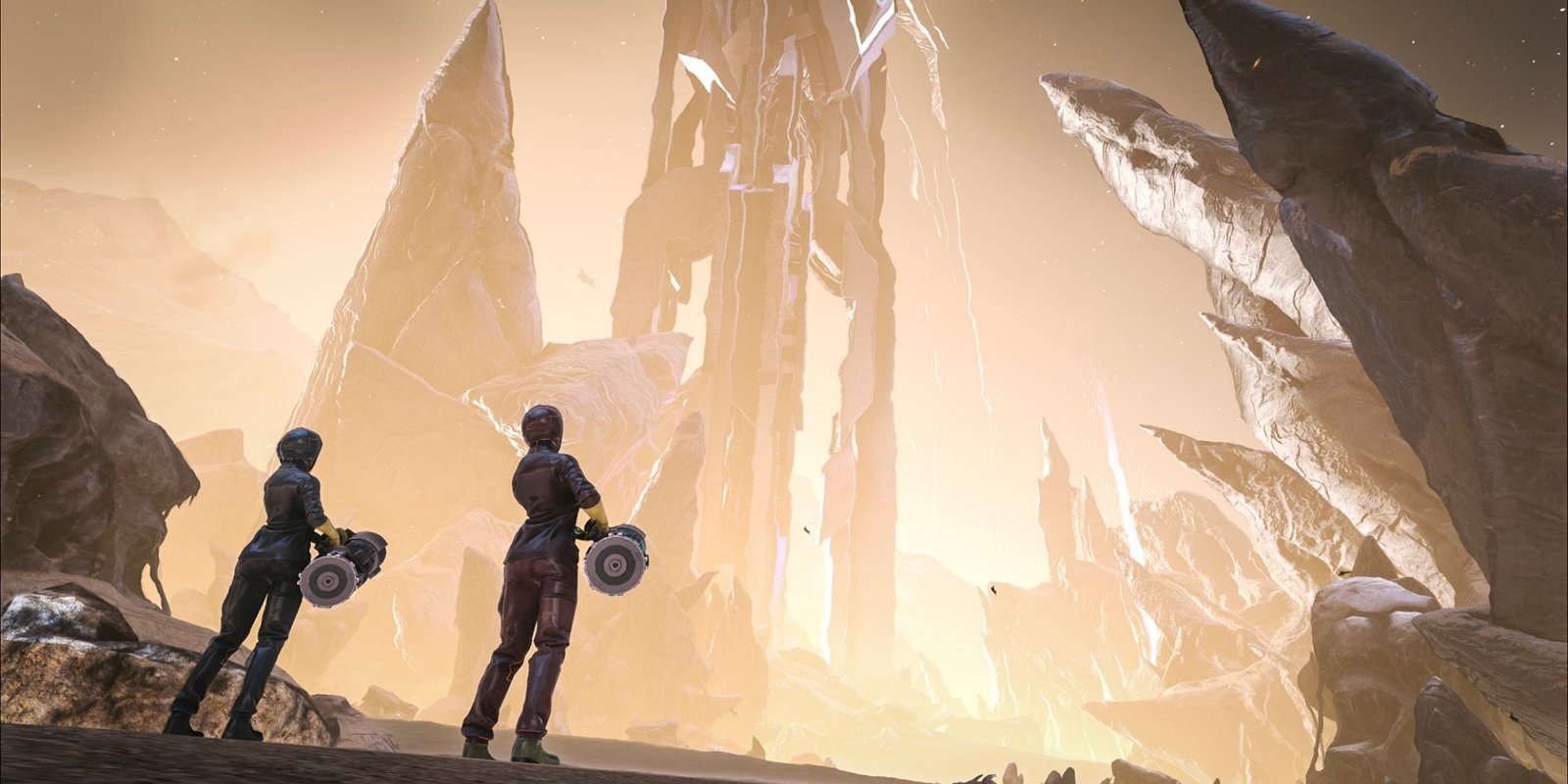 Two players in full body suids look on at the wasteland that the surface has become