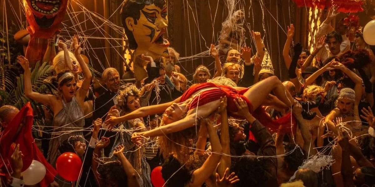 Margot Robbie being carried through a crowd at a party in Babylon